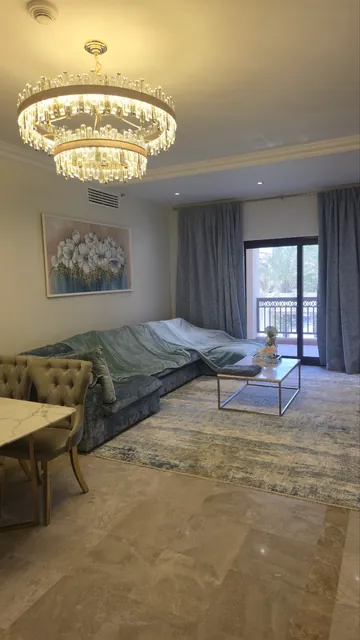 Living room after the renovation: marble floor, chandelier, curtains