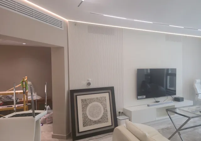 TV lounge with fluted wall panels and cove lighting