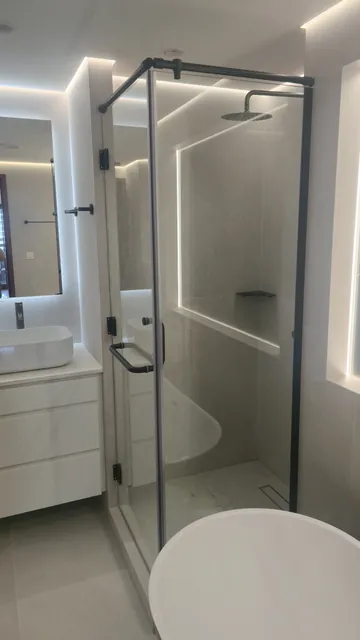 Shower room with walk-in glass screen and backlit mirror