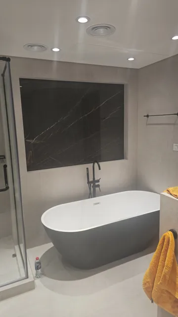 Bathroom with freestanding bath and black marble feature wall